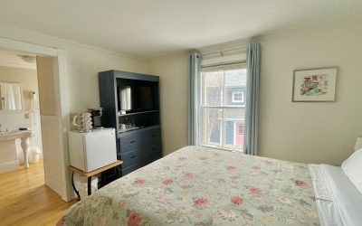 Room with queen bed, window, tv, coffee station and tv and ensuite bathroom